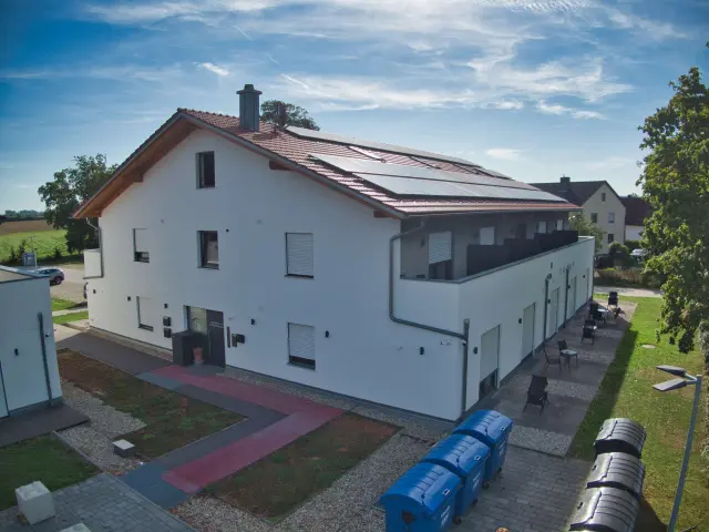 Seitenansicht der Unterkunft in Dingolfing mit Zufahrt und Stellplätzen