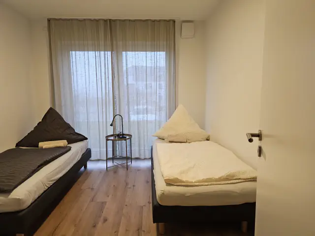 Schlafzimmer in einer Monteurunterkunft in Großköllnbach mit zwei Einzelbetten