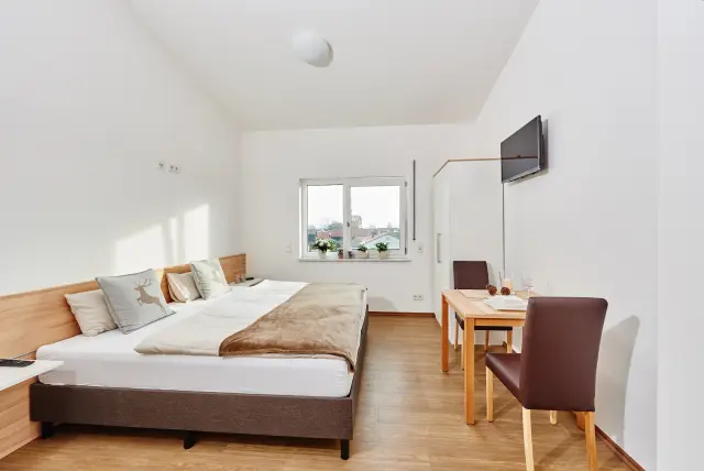 Möbliertes Monteurzimmer in Haidlfing mit Bett, TV und Sitzgelegenheit
