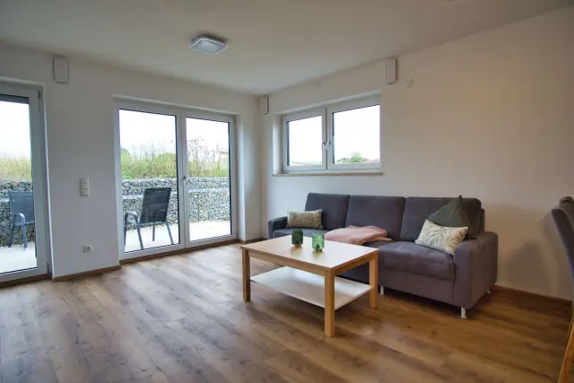 Wohnbereich einer möblierten Unterkunft in Hankofen mit Sofa und Terrassenzugang