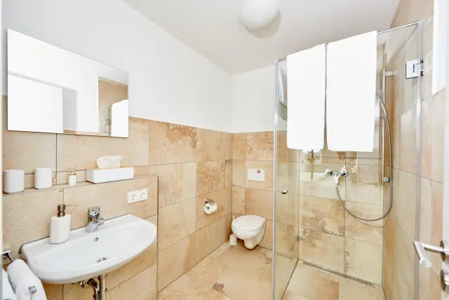 Bad der Monteurunterkunft in Pilsting mit Dusche und Waschbecken