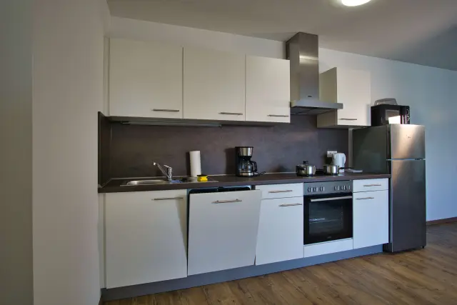 Apartmenthaus in Plattling mit Küchenzeile, Esstisch und TV