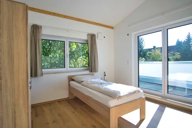 Schlafzimmer einer Monteurunterkunft in Plattling mit Bett und Schrank